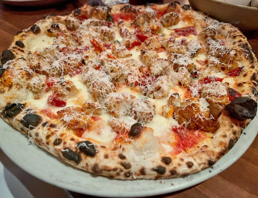 A wood-fired flatbread coming out of the stone oven